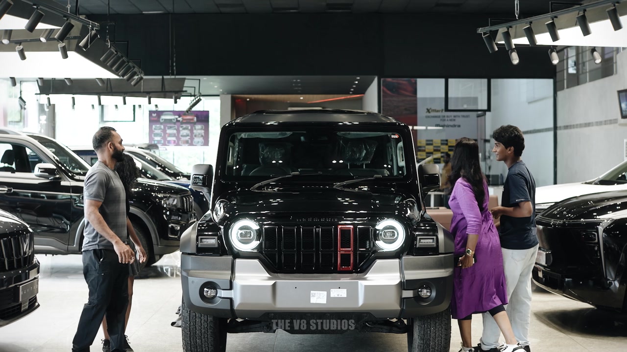 Gilbert and family with a Mahindra Thar Roxx during a dealership delivery film